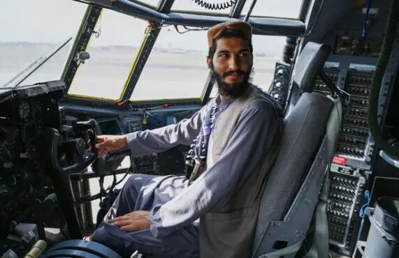 在美国撤军并留下设备后塔利班战士在阿富汗空军飞机的驾驶舱内摆姿势