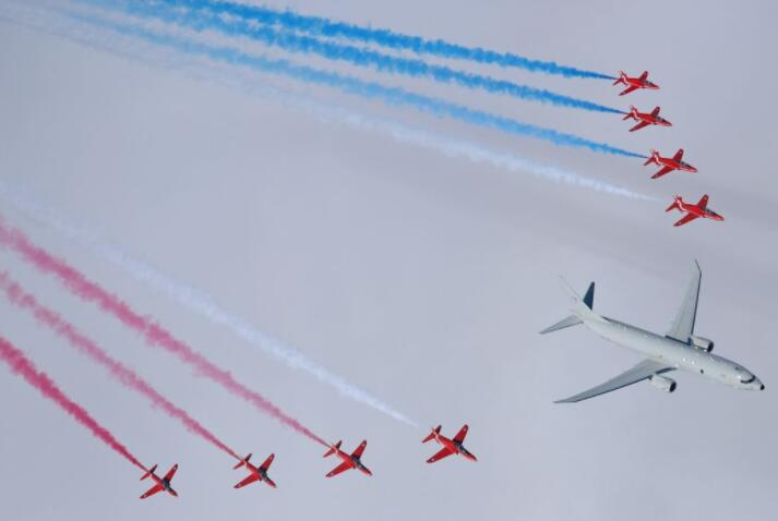 英国皇家空军的红色箭头在联合飞行中从强大的潜艇猎人波塞冬侧翼