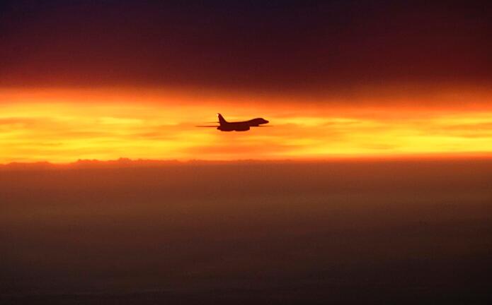 强大的重型轰炸机在红海的橙色天空中看起来微不足道