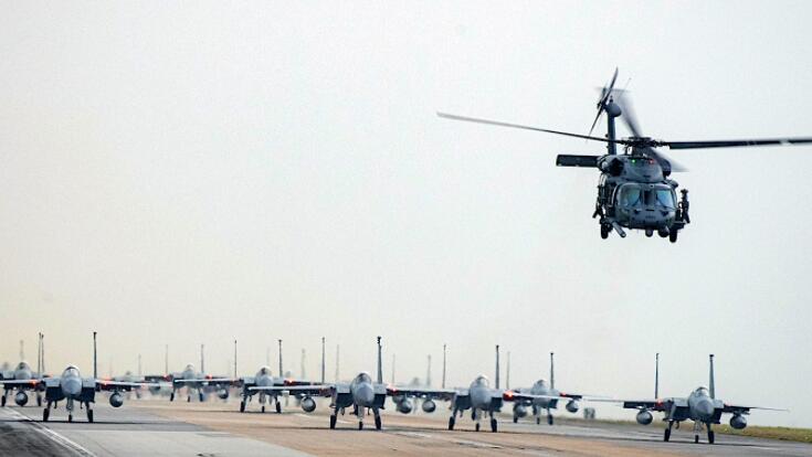 F-15C/D老鹰的大规模编队跟随直升机沿着跑道降落